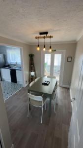 a dining room with a table and chairs and a kitchen at Donrae in Portree