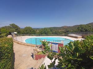 a large swimming pool with a fence around it at Sun and Sea LT - Piscina Condominiale - PMS CaseVacanze in Budoni
