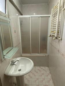 a white bathroom with a sink and a shower at Saltanat Apartment in Istanbul +12 photos