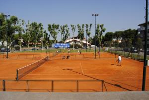 a group of people playing tennis on a tennis court at Residence Braida in Caorle