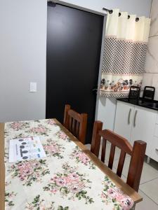 a kitchen with a table and chairs and a black door at Casa aconchegante in Timbó