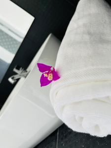 a purple flower sitting on top of a white pillow at Letharo Residancies in Dodanduwa