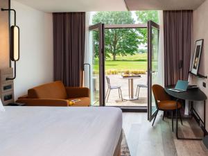 a hotel room with a bed and a patio at Novotel Saint-Quentin en Yvelines in Magny-les-Hameaux +38 photos