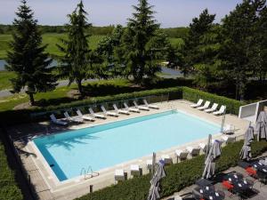 an overhead view of a swimming pool with lounge chairs at Novotel Saint-Quentin en Yvelines in Magny-les-Hameaux