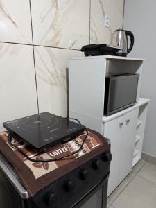 a laptop sitting on top of a stove in a kitchen at Casa aconchegante in Timbó +2 photos