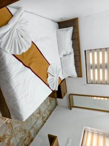 ein Bett in einem kleinen Zimmer mit einem Spiegel in der Unterkunft Ocean Mist in Kozhikode + 3 Fotos