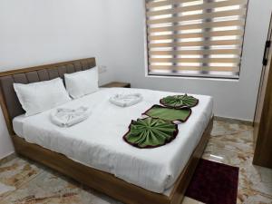 ein Bett mit weißen Laken und grünen Handtüchern darauf in der Unterkunft Ocean Mist in Kozhikode