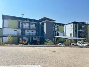 a row of apartment buildings with a parking lot at 166 Green valley in Boschrand