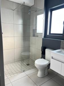 a bathroom with a toilet and a glass shower at 166 Green valley in Boschrand +12 photos