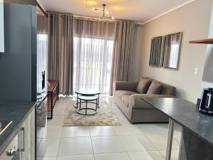 a living room with a couch and a table at 166 Green valley in Boschrand