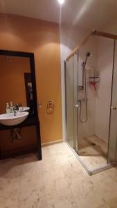 a bathroom with a glass shower and a sink at Апартамент София in Golden Sands +27 photos