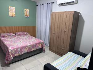 a bedroom with a bed and a wooden cabinet at Casa aconchegante in Timbó