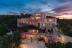 a large pink building on top of a hill at Hotel Boutique Il Castellino Relais in Vieste