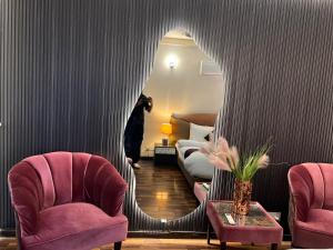 a room with a mirror and two chairs and a bed at ELYSIUM TOWER Luxury Hotel Apartments Facing Centaurus Mall Islamabad in Islamabad