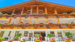 a building with a balcony with plants on it at Baita dei Pini in Campodolcino