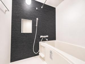 a bathroom with a shower with a black wall at Excel 琴似 -FIX HOME- in Sapporo +8 photos