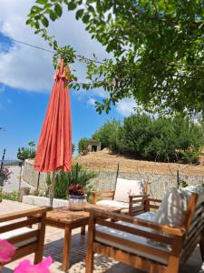 Eine Terrasse mit zwei Bänken und einem Sonnenschirm in der Unterkunft U' Cerrito in Orria