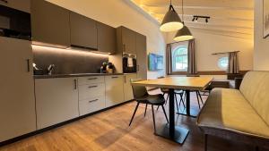 a kitchen with a wooden table and a dining room at Marktplatz Apartments Lofer in Lofer