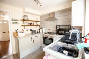 a kitchen with a sink and a stove at 2 Crown Barton in Glastonbury