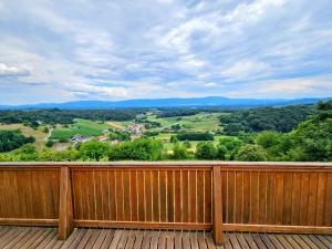 a wooden deck with a view of a valley at Pirman Vineyard Cottage in Bučka