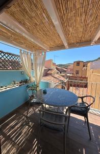 a table and chairs on a balcony with a view at DOMMO ASULETTA in Bosa