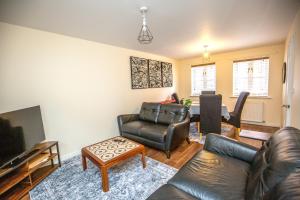 a living room with a couch and a tv and a table at 2 Crown Barton in Glastonbury