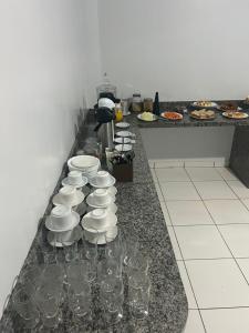 a counter with plates and cups and wine glasses at Hotel Goiamat in Querencia
