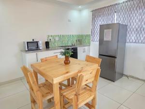 a kitchen with a wooden table and a refrigerator at Vinview 2 bedroom apartment in Swakopmund
