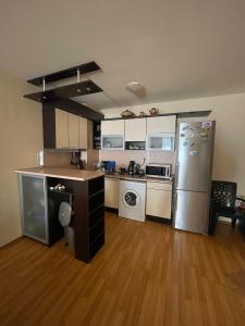 a large kitchen with a refrigerator and a stove at Апартамент София in Golden Sands