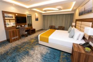 a hotel room with a large bed and a desk at Moments in Jeddah