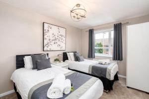a bedroom with two beds and a chandelier at Meadow Park Villas in Manchester
