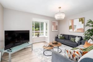 a living room with a couch and a large tv at Meadow Park Villas in Manchester