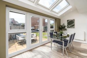 a dining room with windows and a table with chairs at Meadow Park Villas in Manchester