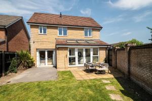a brick house with a table in the yard at Meadow Park Villas in Manchester