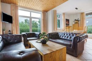a living room with leather couches and a table at Haus 17 in Röbel