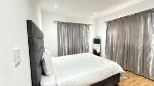 a bedroom with a white bed and a window at Vinview 2 bedroom apartment in Swakopmund
