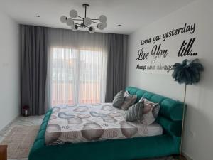 a bedroom with a green couch and a bed at Duplex prestige in El Achour