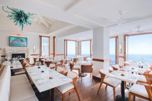 a restaurant with tables and chairs and a fireplace at Surf & Sand Laguna Beach in Laguna Beach