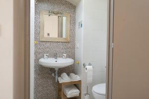 a bathroom with a sink and a toilet and a mirror at Dimora dei Grifi in Ascoli Satriano