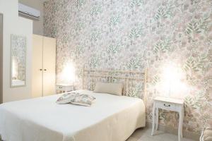 a bedroom with a bed with a pink floral wallpaper at Dimora dei Grifi in Ascoli Satriano