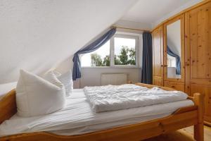 a bedroom with a white bed with a window at Haus 17 in Röbel