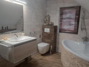 a bathroom with a sink and a tub and a toilet at Green Valley Guesthouse in Izvoru Mureşului +72 photos