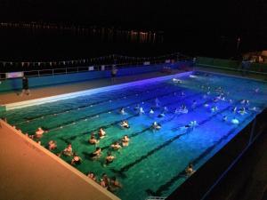 a group of people in a swimming pool at night at Beautiful 2 double bedrooms, 2 baths apartment in Port Glasgow