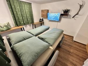 two beds in a room with green sheets at apart-gerlos in Gerlos
