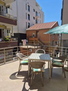 a patio with a table and chairs and an umbrella at M&M Apartman 2 in Rafailovici