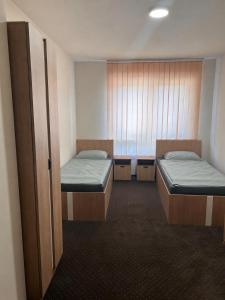 a room with two beds and a window at Aura Pokoje na Wynajem in Wojnicz +1 photo