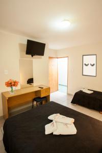 a hotel room with a bed and a desk with towels at Bonito Hotel in San Rafael