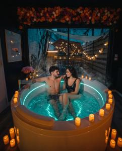 a man and a woman sitting in a hot tub at L'Eure de Luxure Loveroom Suite in Normandy in Évreux