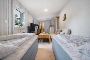 a row of beds in a room with a tv at Fewo Gustav Melkert Str. 5A in Röbel