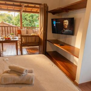 a living room with a television on the wall at Residência Thomas in Itacaré